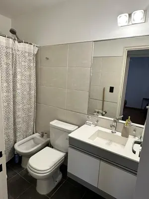 a bathroom with a toilet and a sink and a mirror at Departamento Nueva Córdoba in Cordoba