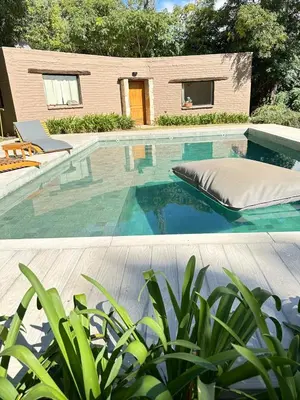 a swimming pool with a bed and a house at La Chascona Suite in Merlo