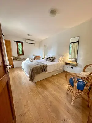 a bedroom with a bed and a table and a chair at La Chascona Suite in Merlo