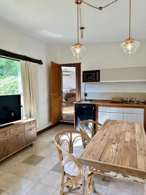a kitchen with a wooden table and chairs and a television at La Chascona Suite in Merlo