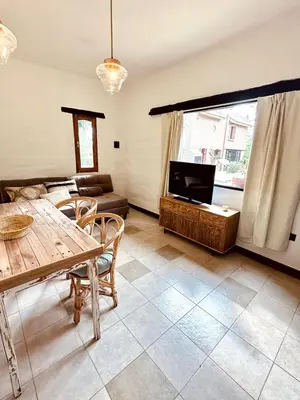 a living room with a table and a tv at La Chascona Suite in Merlo