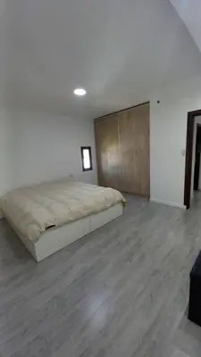 a bedroom with a large bed and a wooden floor at Alojamiento en Villa La Bolsa in La Bolsa