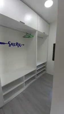 a room with white cabinets with a sign on the wall at Alojamiento en Villa La Bolsa in La Bolsa