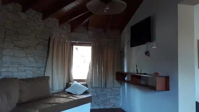 a living room with a couch and a window at Liquidambar in Villa General Belgrano