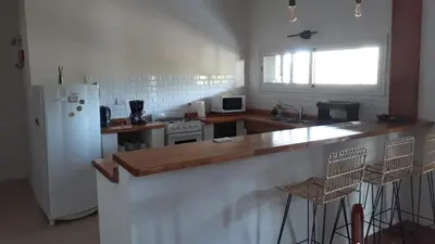 a kitchen with a counter and a white refrigerator at Liquidambar in Villa General Belgrano
