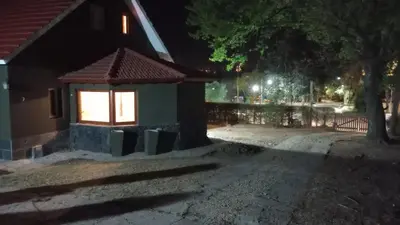 a small building with a window on a street at night at Liquidambar in Villa General Belgrano