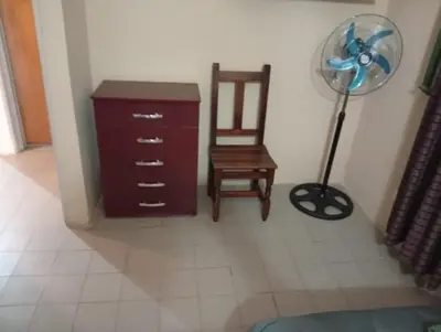 a room with a dresser and a chair and a fan at Alojamiento Lo de Jaime in Merlo