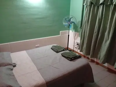 a room with a bed with a fan next to a window at Alojamiento Lo de Jaime in Merlo