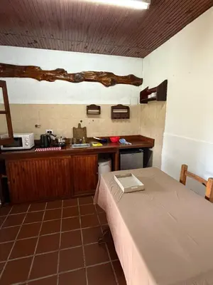 a room with a bed and a kitchen with a counter at Cabañas La Cautiva in Tanti