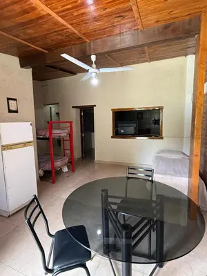 a living room with a glass table and a bed at Cabañas La Cautiva in Tanti