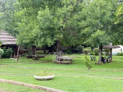 a park with a picnic table and benches and trees at Cabañas La Cautiva in Tanti
