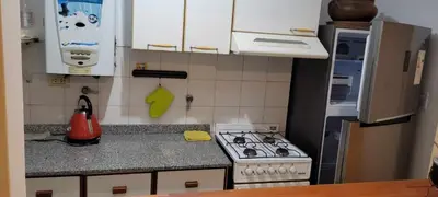 a small kitchen with a stove and a refrigerator at Departamento Lugones Nva Córdoba in Cordoba