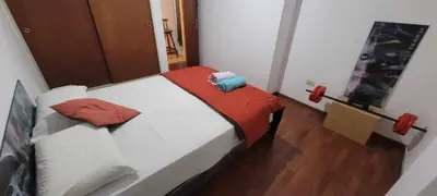 a bedroom with a white bed with red sheets at Departamento Lugones Nva Córdoba in Cordoba