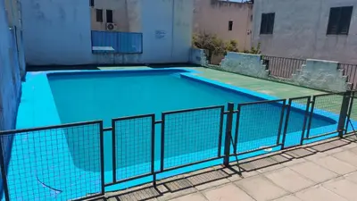 a large swimming pool with a fence around it at Castillo Del Lago Hospedaje Compartido in Villa Carlos Paz