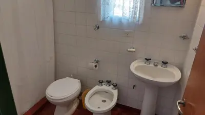a small bathroom with a toilet and a sink at Castillo Del Lago Hospedaje Compartido in Villa Carlos Paz