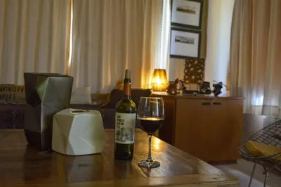a bottle of wine and a glass on a table at Casa Almendro-Chumamaya-Villa de Merlo in Country Club Chumamaya