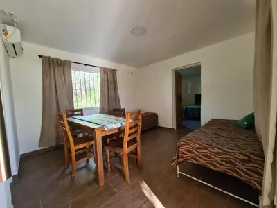 a room with a table and chairs and a bed at La Tranquilidad in Merlo