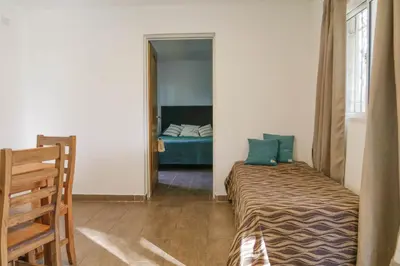 a small bedroom with a bed and a mirror at La Tranquilidad in Merlo