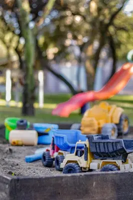 a toy dump truck and other toys in a sandbox at La Tranquilidad in Merlo