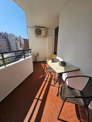 a balcony with a table and chairs on a building at Mamina Apartamento in Cordoba