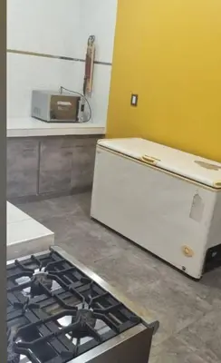 a kitchen with a stove and a white refrigerator at Cabaña De La Sierra in Villa Yacanto