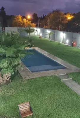 a backyard with a swimming pool in the grass at Cabaña De La Sierra in Villa Yacanto
