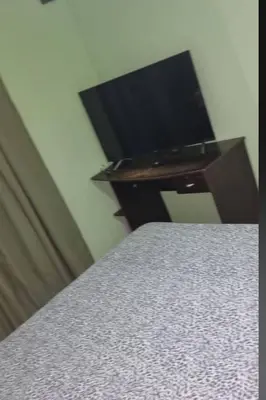 a bedroom with a bed and a television on a desk at Cabaña De La Sierra in Villa Yacanto