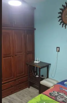 a bedroom with a wooden cabinet and a table at Cabaña De La Sierra in Villa Yacanto
