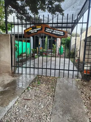 a black metal fence with a playground behind it at Posada Abuelo Miguel in Villa Cura Brochero