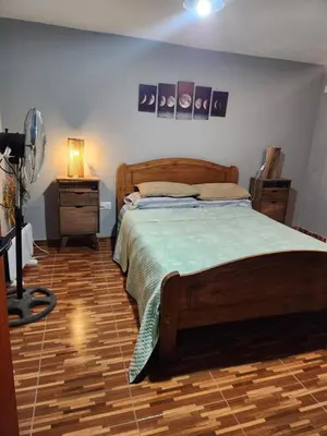 a bedroom with a large bed with a wooden floor at Posada Abuelo Miguel in Villa Cura Brochero