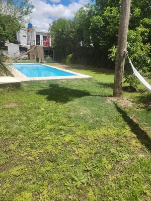 a swimming pool in a yard with a tree at Posada Abuelo Miguel in Villa Cura Brochero