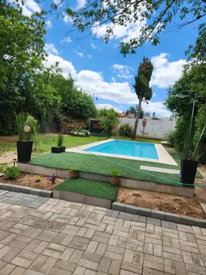 a swimming pool in a yard with a lawn at Posada Abuelo Miguel in Villa Cura Brochero