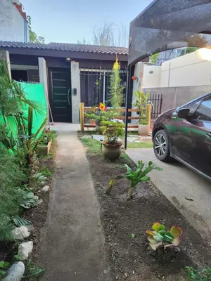 a driveway with a car parked in front of a house at Posada Abuelo Miguel in Villa Cura Brochero