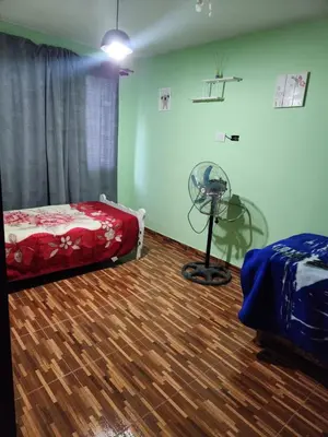a room with a bedroom with a bed and a fan at Posada Abuelo Miguel in Villa Cura Brochero
