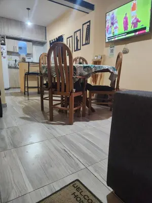 a dining room with a table and chairs and a tv at Posada Abuelo Miguel in Villa Cura Brochero