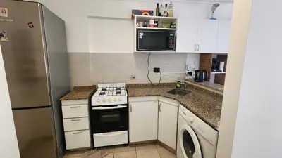 a small kitchen with a stove and a refrigerator at Departamento Salguero Nueva Córdoba in Cordoba