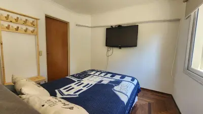 a room with a couch and a tv on a wall at Departamento Salguero Nueva Córdoba in Cordoba