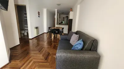a living room with a couch and a wooden floor at Departamento Salguero Nueva Córdoba in Cordoba