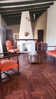 a living room with orange chairs and a fireplace at Casa Dos Lunas Cordoba in Cordoba
