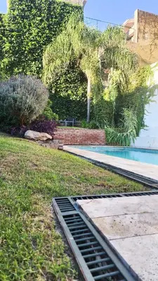 a swimming pool with a grate in the grass at Casa Dos Lunas Cordoba in Cordoba