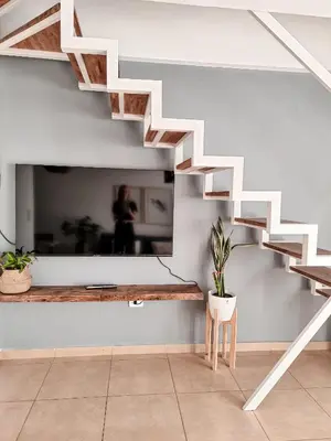 a staircase in a living room with a potted plant at Dpto independencia 1446 - Pileta, Terraza, Asadores in Cordoba