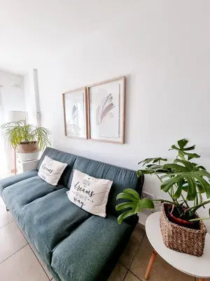 a blue couch in a living room with plants at Dpto independencia 1446 - Pileta, Terraza, Asadores in Cordoba