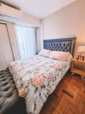 a bedroom with a bed with flowers on it at Dpto independencia 1446 - Pileta, Terraza, Asadores in Cordoba