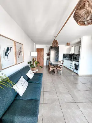 a living room with a blue couch and a kitchen at Dpto independencia 1446 - Pileta, Terraza, Asadores in Cordoba