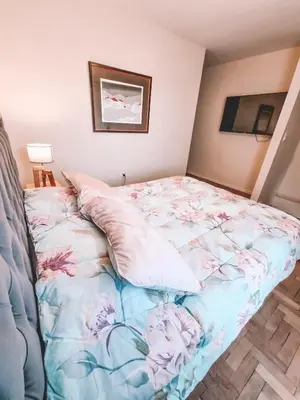 a bedroom with a bed with flowers on it at Dpto independencia 1446 - Pileta, Terraza, Asadores in Cordoba