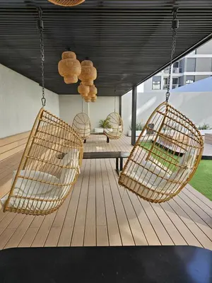 a porch with three rattan chairs hanging from a ceiling at Dpto Ambrosio Olmos 1090 - Pileta, Asadores, Terraza, Quincho in Cordoba