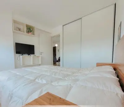 a bedroom with a large white bed with a glass wall at Departamento Antigua Cervecería - Nati - in Cordoba