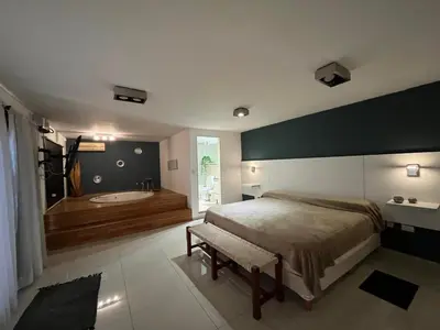 a bedroom with a large bed and a bath tub at Departamento Duarte Quirós in Cordoba