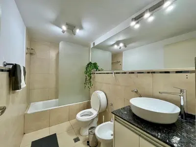 a bathroom with a sink and a toilet and a tub at Departamento Duarte Quirós in Cordoba