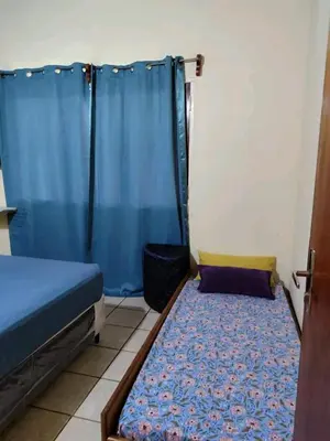 a small room with a bed and a blue curtain at Alquiler luque in Mina Clavero